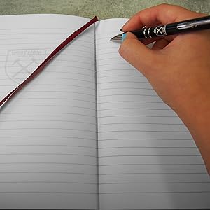 Ruled pages of notebook being written into with West Ham pen
