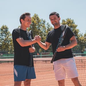 two men shaking hands on a tennis court