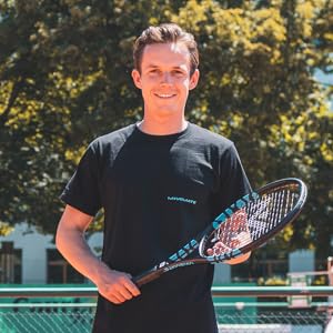 a young man standing on a tennis court holding a racquet.